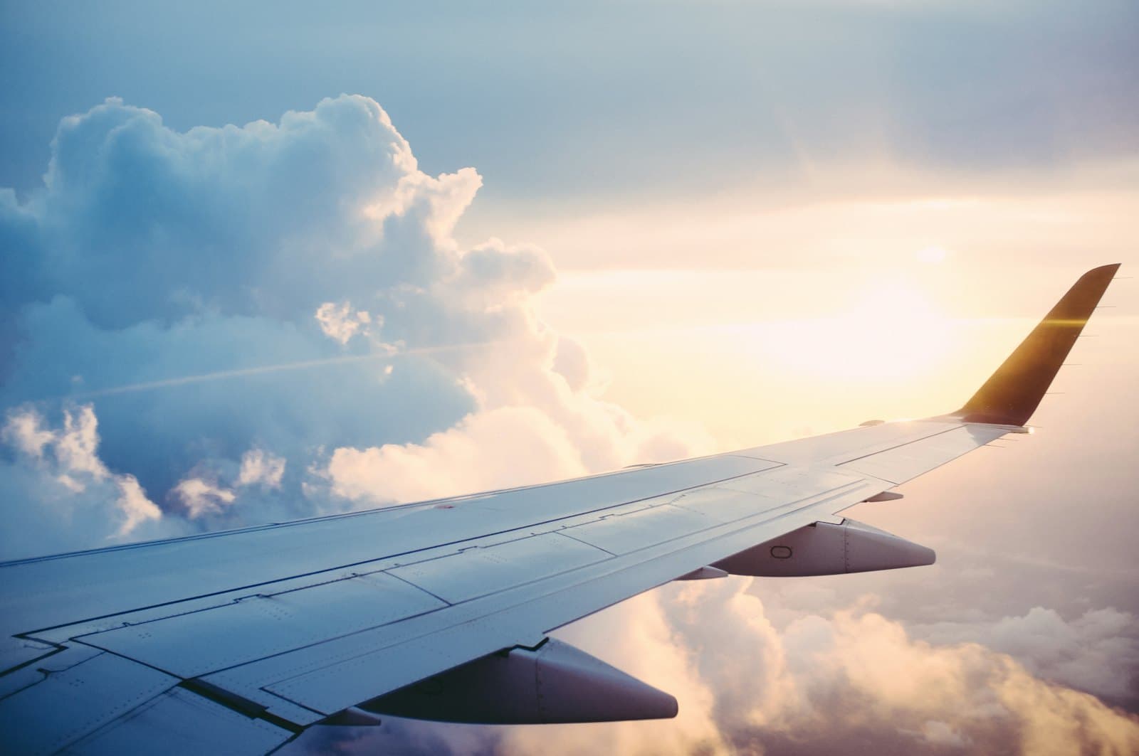 Aircraft wing above a cloud deck at golden hour